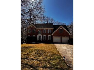 Charming two-story brick home with a well-manicured lawn and a two-car garage at 136 Hunters Ct, Dallas, GA 30157