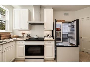 Well-equipped kitchen with white cabinets, granite counters, and stainless steel appliances at 435 10Th Ne St # 18, Atlanta, GA 30309