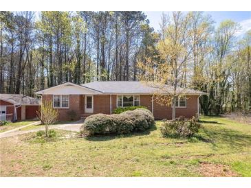 Charming brick home with a well-maintained front yard and mature landscaping at 4693 Sugar Hill Se Rd, Acworth, GA 30102