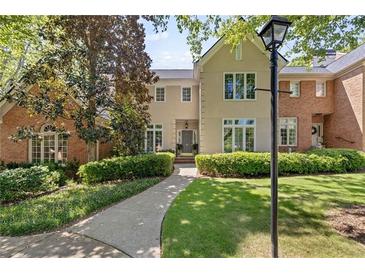 Charming home featuring manicured landscaping and a walkway leading to the front door at 15 Paces West Nw Dr, Atlanta, GA 30327