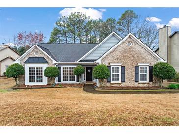Charming brick home featuring a manicured front yard and inviting curb appeal at 3130 Goldmist Dr, Buford, GA 30519