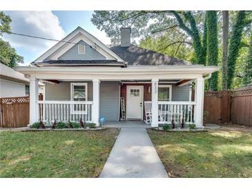 Charming home featuring a welcoming front porch with rocking chairs and well-maintained landscaping at 833 N Grand Nw Ave, Atlanta, GA 30318