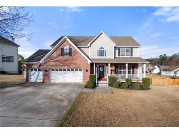 Charming two-story brick home with a welcoming front porch and a well-manicured lawn at 1191 Fountain Head Ct, Lawrenceville, GA 30043