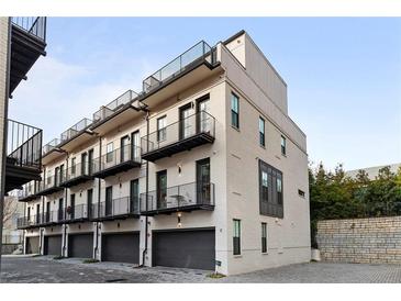 Modern townhome with painted brick, black trim, balconies, and attached garages at 574 Boulevard Ne Pl # 5, Atlanta, GA 30308