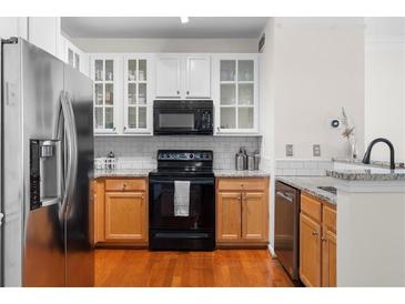 Modern kitchen with stainless steel refrigerator, granite counters and white subway tile backsplash at 375 Highland Ne Ave # 908, Atlanta, GA 30312