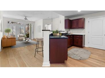 Open kitchen and living area with stainless appliances and hardwood floors, bright and modern at 390 17Th Nw St # 1063, Atlanta, GA 30363
