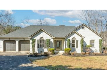 Charming white brick home with a three-car garage and well-manicured landscaping at 8160 Stone Hill Rd, Cumming, GA 30028