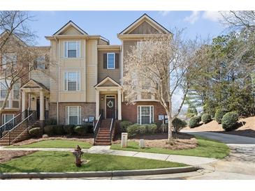 Charming townhome featuring brick and siding exterior, with manicured lawn and inviting entryway stairs at 3930 Covey Flush Sw Ct # 21, Smyrna, GA 30082