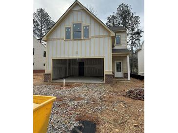 New home exterior with a two-car garage awaiting finishing touches with a yard ready for landscaping at 4285 Easter Lily Ave, Buford, GA 30519