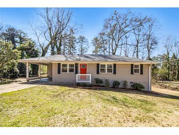 Charming brick home featuring a bright red front door and a covered carport at 1113 Grace Sw St, Mableton, GA 30126