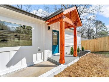 Welcoming front door with eye-catching wood pillar entryway detail and adjacent fenced in yard and attractive landscaping at 926 Natham Dr, Atlanta, GA 30315
