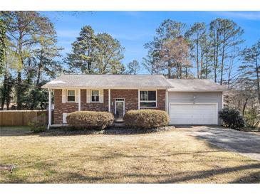 Charming brick home featuring a well-manicured lawn and attached one-car garage at 959 Frontier Sw Trl, Marietta, GA 30060