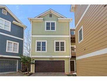 Charming two-story home featuring a one car garage and light green siding at 735 Ponce De Leon Ne Pl, Atlanta, GA 30306