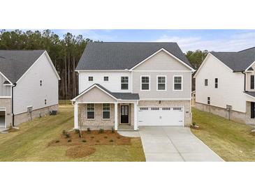 Charming two-story home with a landscaped yard, a gray roof, a two car garage, and neutral color palette at 13238 Tolstoy, Covington, GA 30014