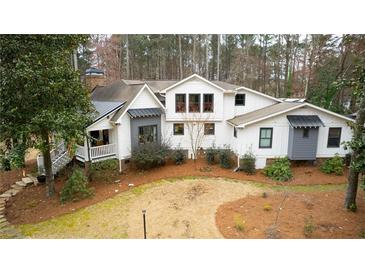 Stunning modern farmhouse with white siding, gray accents, and a professionally landscaped yard at 4770 Hilltop Nw Dr, Acworth, GA 30101