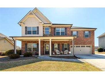 Charming two-story brick home with a welcoming front porch and well-manicured lawn at 2401 Day Break Way, Dacula, GA 30019