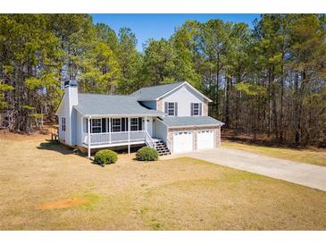 Charming two-story home featuring a covered porch, two-car garage, and beautifully landscaped front yard at 195 W Fork Way, Temple, GA 30179