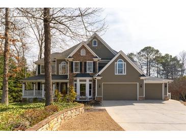 Charming two-story home with a stone and siding exterior, three-car garage and well-manicured landscaping at 764 Sharpshooters Nw Rdg, Marietta, GA 30064