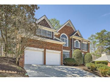 Beautiful brick two-story home with a two-car garage and a well-manicured front yard at 5106 Vinings Estates Se Way, Mableton, GA 30126