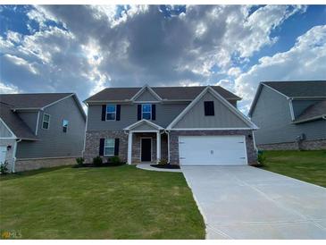 Two-story home with gray siding, brick accents, well-manicured lawn, and a two-car garage at 117 Oliver Dr, Locust Grove, GA 30248