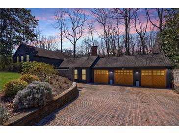 Stunning home exterior with a three-car garage and a beautiful brick driveway at 1110 Vernon Springs Ct, Atlanta, GA 30327