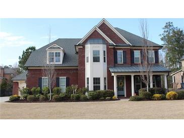 Beautiful two-story brick home with a manicured lawn and a welcoming front porch at 2480 Copper Mill Trl, Cumming, GA 30041