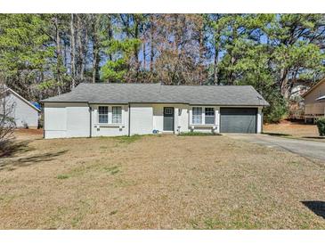 Charming single story home with a gray roof, a dark garage door, and white brick walls at 3915 Basil Sw Way, Atlanta, GA 30331