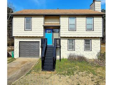 Charming two-story home with a bright blue door and a cozy, inviting entrance and a convenient garage at 5550 Mccrossin Cir, Stonecrest, GA 30038