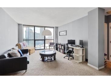 Spacious living room with floor-to-ceiling windows and comfortable seating, perfect for relaxing or entertaining at 1280 W Peachtree Nw St # 2613, Atlanta, GA 30309
