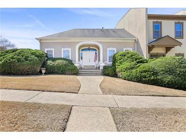 Charming home with a well-manicured front yard and a stately entrance featuring an arched doorway at 9390 Knollcrest, Alpharetta, GA 30022