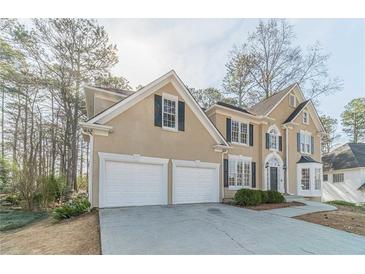 Charming two-story home with neutral stucco, black shutters, white trim, and a spacious two-car garage at 1351 Mckendree Park Ct, Lawrenceville, GA 30043