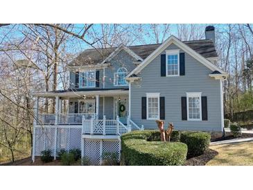 Charming two-story home featuring a welcoming front porch and meticulously manicured landscaping at 4460 Wimberly Way, Cumming, GA 30028