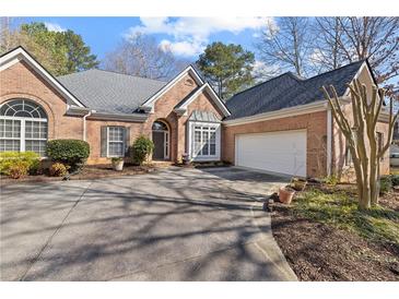 Beautiful brick home with a well-manicured lawn, a two-car garage, and an ample driveway at 8424 Fairway Dr, Covington, GA 30014