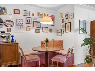 Cozy breakfast nook with unique gallery wall, built-in seating, and hardwood floors at 885 Briarcliff Ne Rd # 16, Atlanta, GA 30306