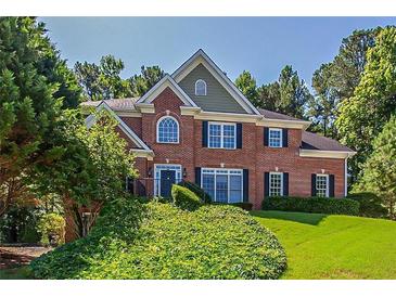 Beautiful brick two-story home with manicured lawn and mature trees at 2088 Hedgewood Trce, Lawrenceville, GA 30043