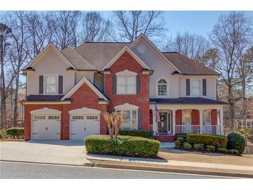 Charming two-story home featuring a brick facade, two-car garage, and inviting front porch at 1175 Lamont Cir, Dacula, GA 30019