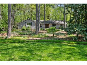 Charming single-story home featuring well-maintained landscaping and a natural setting at 1959 Grand Prix Ne Dr, Atlanta, GA 30345