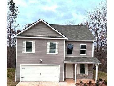 Charming two-story home with a gray exterior and a white garage door under a cloudy sky at 116 Deer Xing, Temple, GA 30179