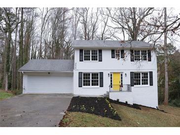 Charming two-story home with a freshly painted exterior, black shutters, and a bright yellow front door at 4620 Central Dr, Stone Mountain, GA 30083