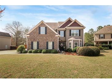 Charming two-story home featuring a well-manicured lawn and a mix of brick and siding accents at 5156 Olive Branch Cir, Powder Springs, GA 30127