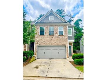 Charming brick townhome featuring a spacious two-car garage and well-manicured landscaping at 4353 Morning Vw, Stone Mountain, GA 30083