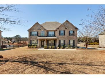 Traditional brick home featuring a manicured front lawn and mature landscaping at 141 Aylesbury Blvd, Mcdonough, GA 30252