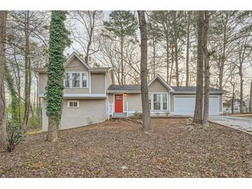 Charming two-story home featuring a neutral color scheme, red front door, and an attached two-car garage at 2436 Wilshire Ct, Decatur, GA 30035