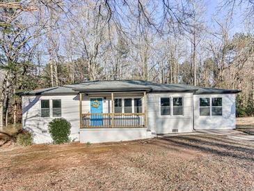 Charming ranch-style home featuring a covered front porch with a bright blue front door at 5205 Silhouette Sw Ln, Mableton, GA 30126