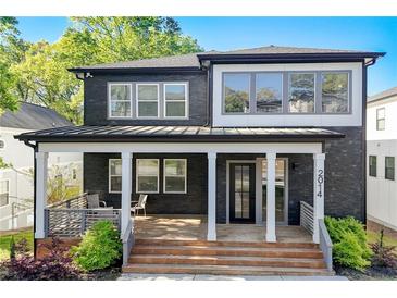Stunning two-story home featuring a modern exterior with a covered porch and inviting entryway at 2014 Cambridge Ave, Atlanta, GA 30337