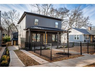 Modern two-story home with dark gray siding, black trim, and a fenced front yard at 1103 Boulevard Se Dr, Atlanta, GA 30317