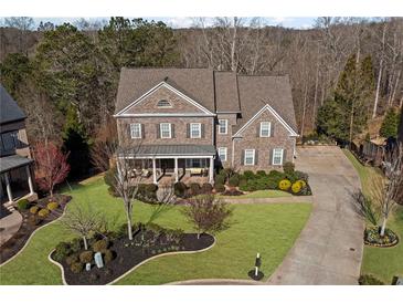 Beautiful brick home with a welcoming front porch and professionally landscaped front yard at 718 Park Haven Ln, Canton, GA 30115