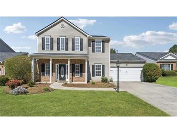 Charming two-story home with a well-manicured lawn, attached garage, and welcoming front porch at 2311 Fall Creek Lndg, Loganville, GA 30052