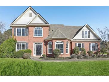 Charming two-story red brick home with manicured lawn and mature landscaping at 2740 Barimore Pl, Dacula, GA 30019