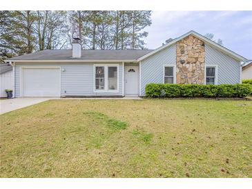 Charming single-story home featuring stone accents, light blue siding and attached one-car garage at 6939 Hickory Log Rd, Austell, GA 30168
